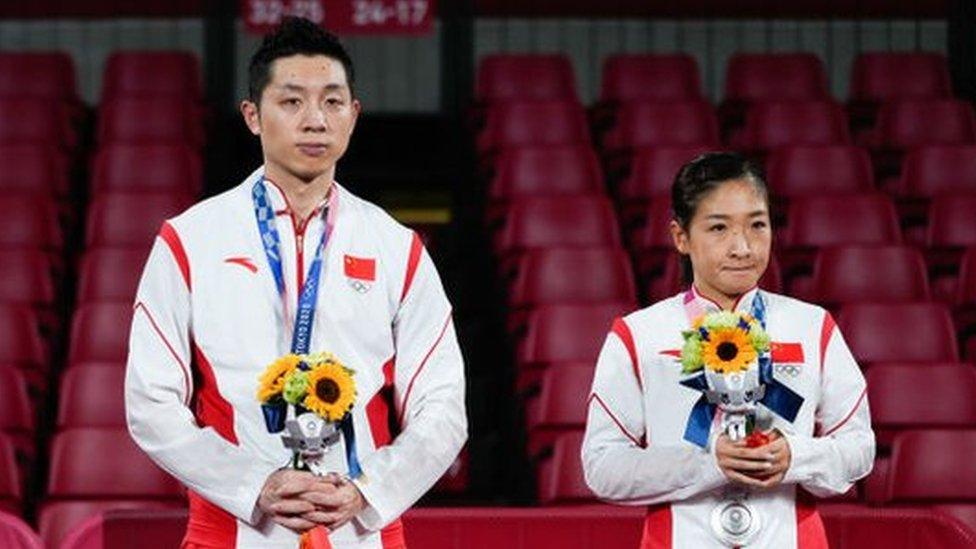 Silver medalists Xu Xin and Liu Shiwen of China pose on the podium after the Mixed Doubles Gold Medal Match against Jun Mizutani and Mima Ito of Japan.