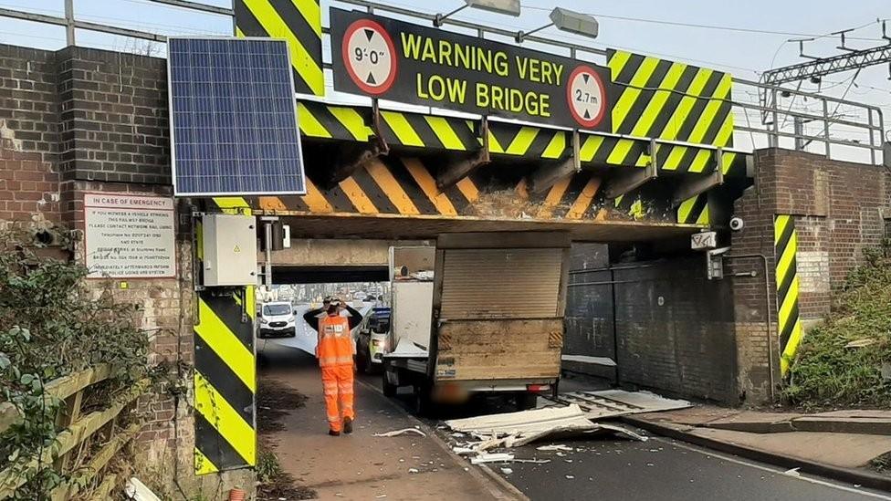 Van stuck under bridge