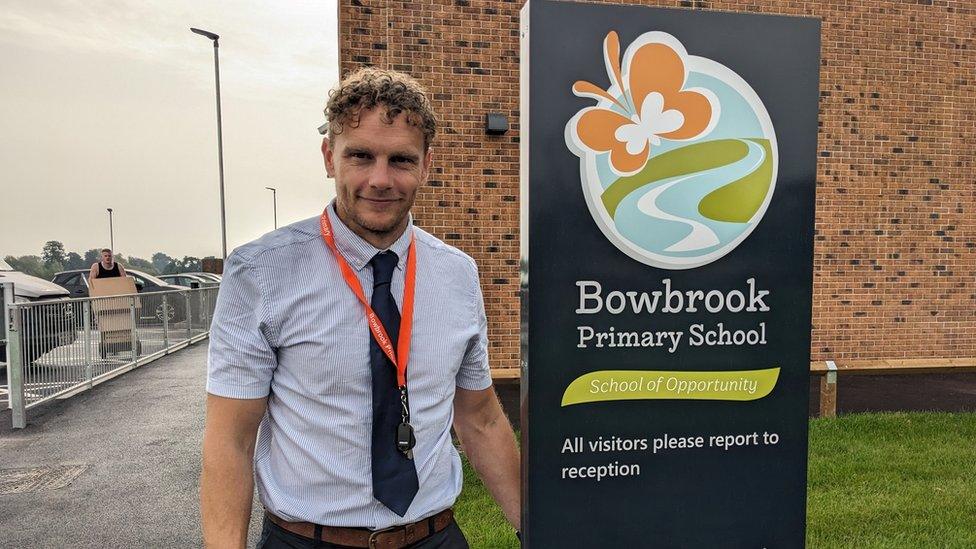 Sam Aiston next to a school sign