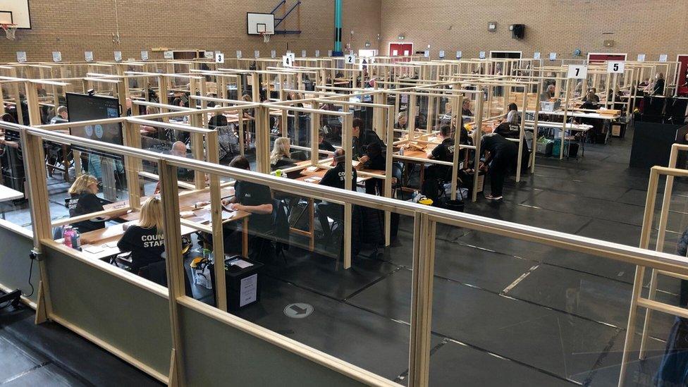 Counters are separated by glass screens, while the count the votes in Ayr