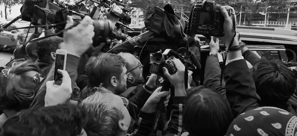 A screengrab from the Harry & Meghan teaser trailer on Netflix, apparently showing the couple being hounded, but actually showing photographers taking pictures of Michael Cohen, Donald Trump's former attorney