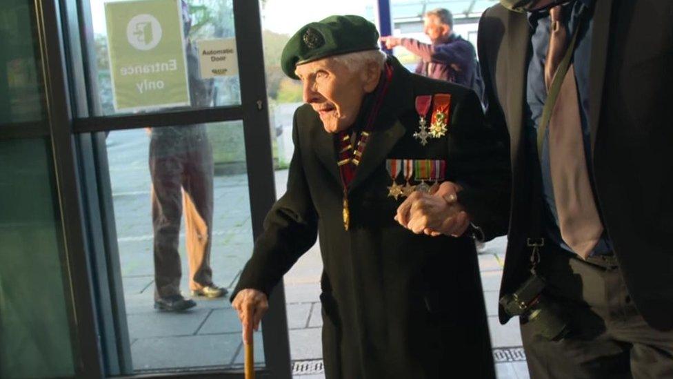 Harry Billinge standing in train station hall