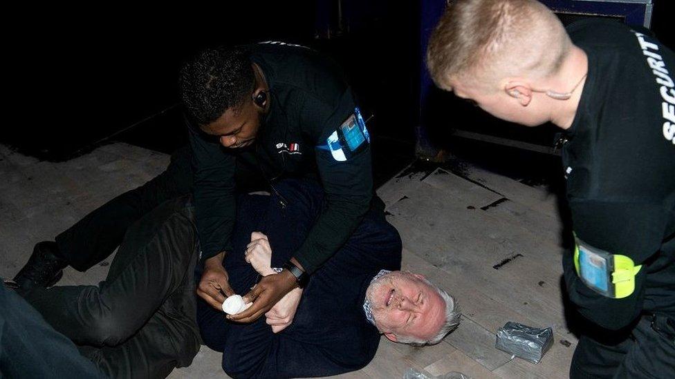 Man on floor being treated by door staff