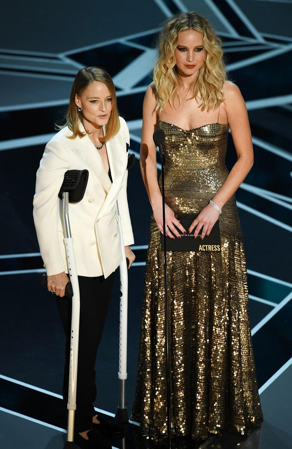 Jodie Foster with crutches and Jennifer Lawrence