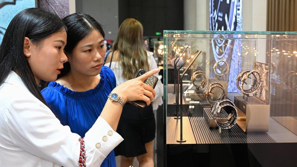 Chinese shoppers look at watches in Haikou, China.