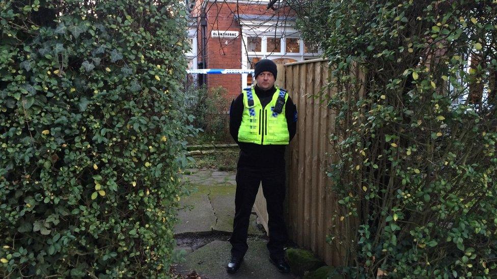 Policeman standing in front of a house