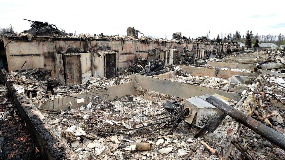 Burnt-out houses in a row, with a destroyed washing machine in the foreground