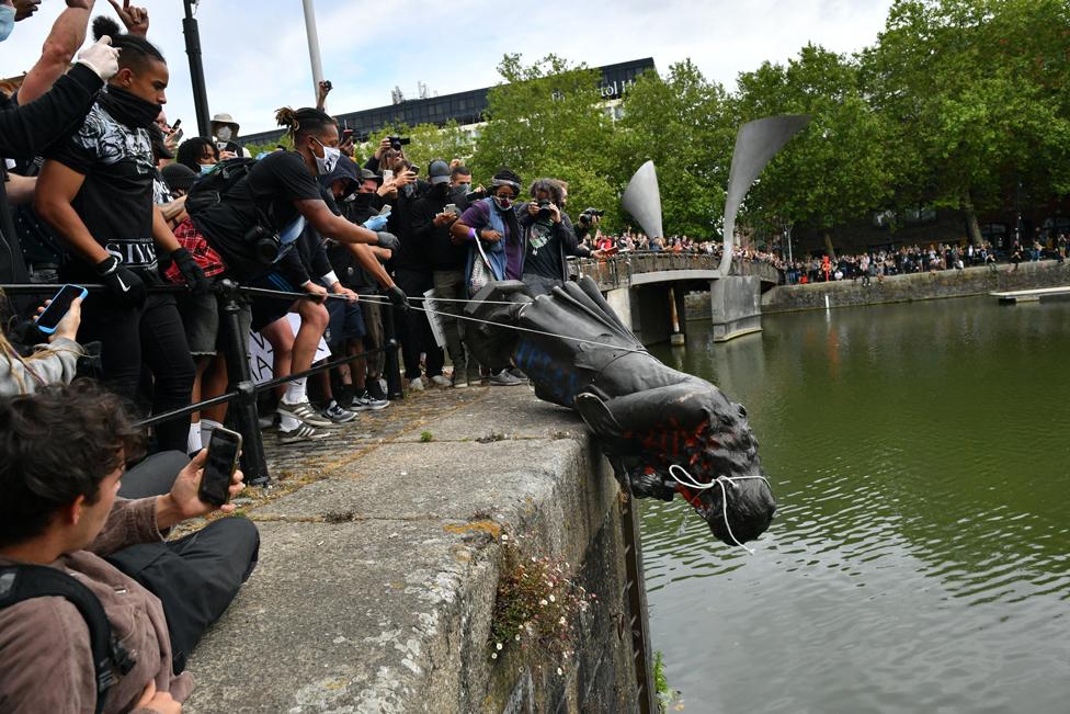 Protesters throwing a statue of Edward Colston into Bristol harbour