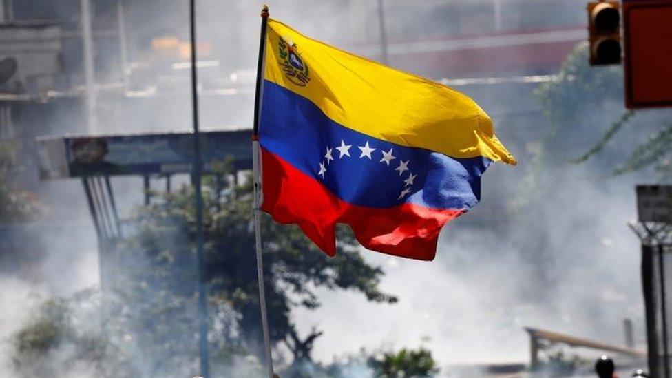 a Venezuelan flag during riots at a march to state Ombudsman"s office in Caracas, Venezuela May 29, 2017.