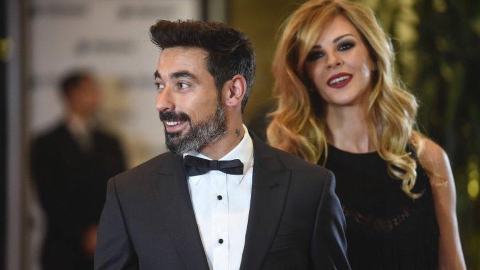 Argentine footballer Ezequiel Lavezzi and his wife pose on a red carpet upon arrival to attend Argentine football star Lionel Messi and Antonella Roccuzzo"s wedding in Rosario, Santa Fe province, Argentina on 30 June 2017.