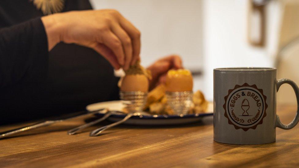 A customer enjoys a boiled egg and toast