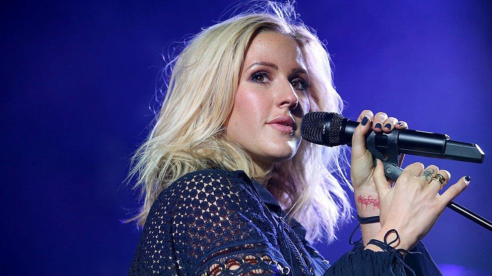 Ellie Goulding holding a microphone singing