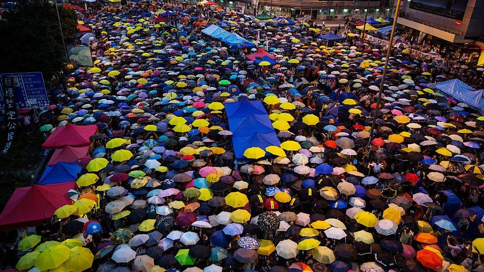 Umbrellas are opened as tens of thousands come to the main protest site one month after the Hong Kong police used tear gas to disperse protesters October 28, 2014 in Hong Kong