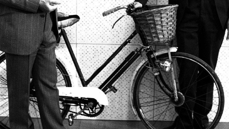 Police officers with the bicycle used by Peter Cook in the 1970s. Is has a wicker basket on the front.