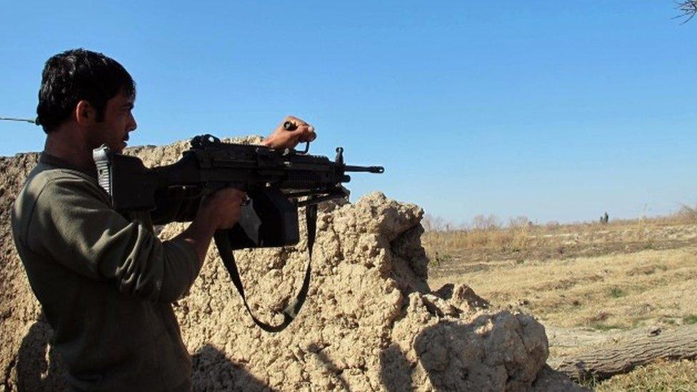 An Afghan National Army (ANA) soldier keeps watch during an ongoing battle with Taliban militants in the Nad Ali district of Helmand (22 December 2015)