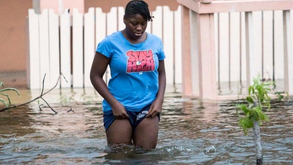 A woman stands in a flooded street in the Bahamas as Hurricane Dorian hits