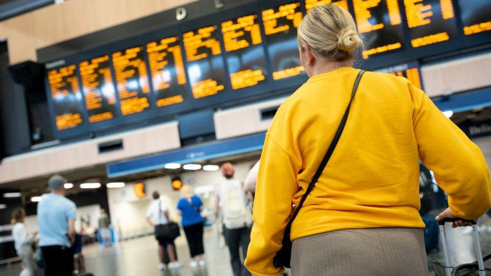 Woman looking at rail departure board