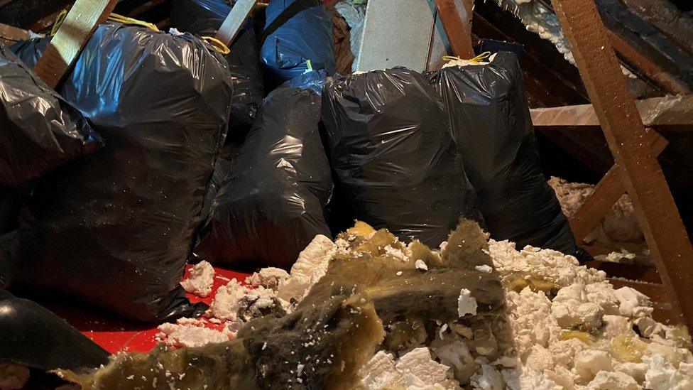 Bin bags full of spray foam waiting to be cleared from a loft