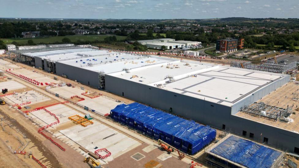 An image from above of a white warehouse under construction.