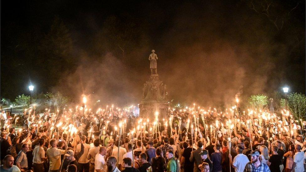 Photo of white nationalist protesters with tiki torches protesting on university campus