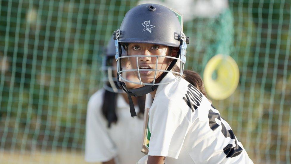 A girl going through batting drills at their academy