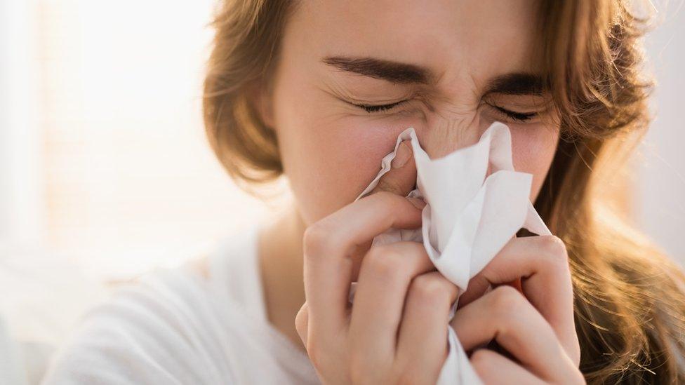 Woman blowing her nose