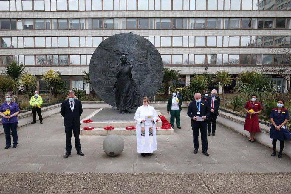 People stand outside St Thomas' Hospital and observe a minute's silence