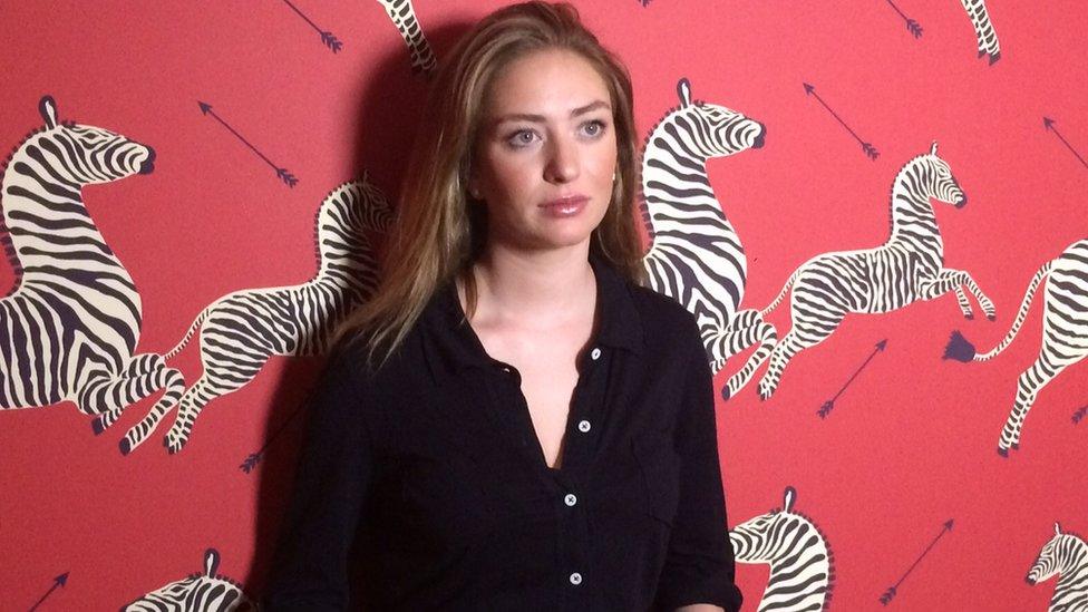 Whitney Wolfe standing in front of patterned wallpaper