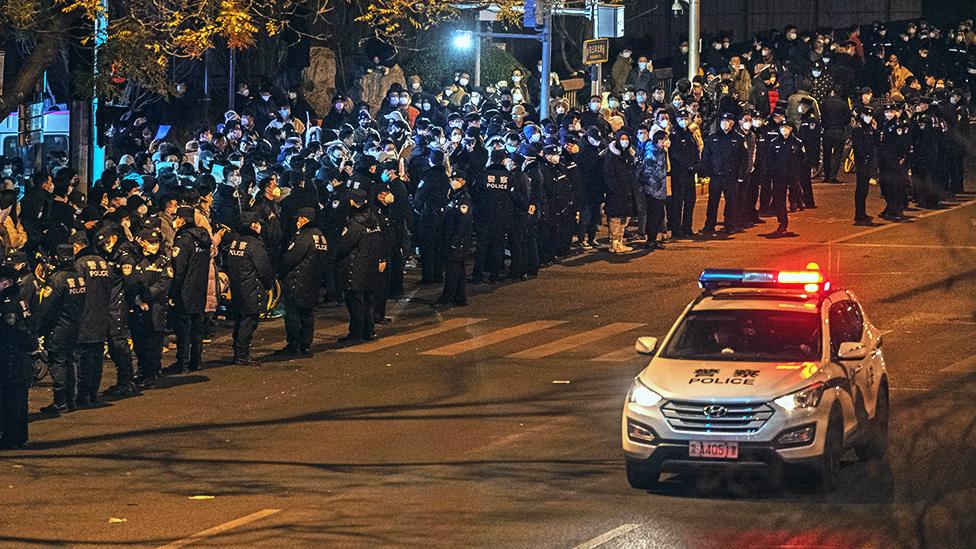 Protesters and police gather during a protest against Chinas strict zero COVID measures on November 28, 2022 in Beijing, China