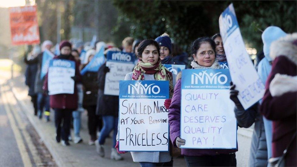 Protesting nurses holding placards marching