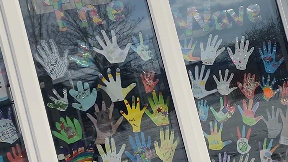 Cut-outs of hands in window