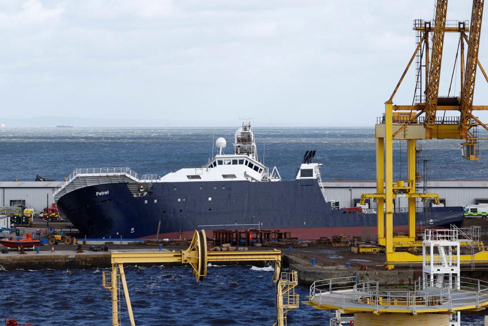 Emergency teams attend the scene after a ship tipped over at a 45-degree angle in the Imperial Dock area in Leith on March 22, 2023 at Imperial Dock in Leith, Scotland.