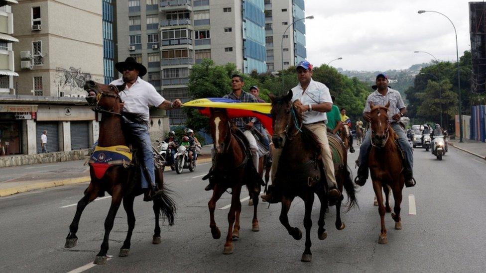 Demonstrators ride on horses and take part in a nationwide protest against President Nicolas Maduro government, in Caracas