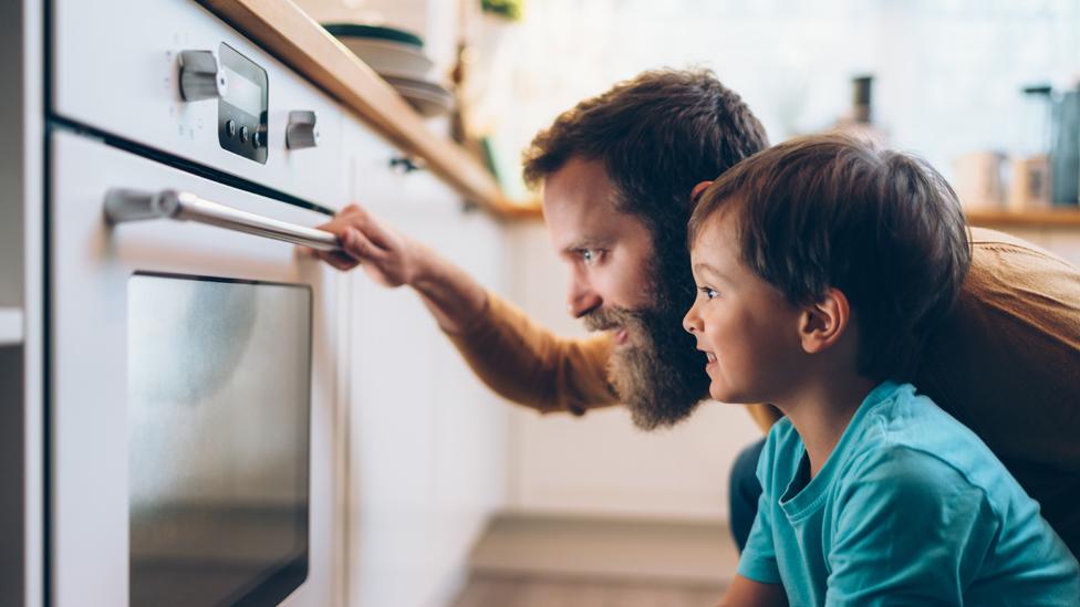 Man and boy look at oven - stock shot