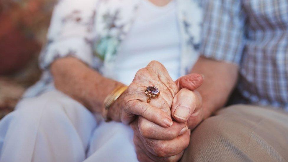 Woman holding man's hand