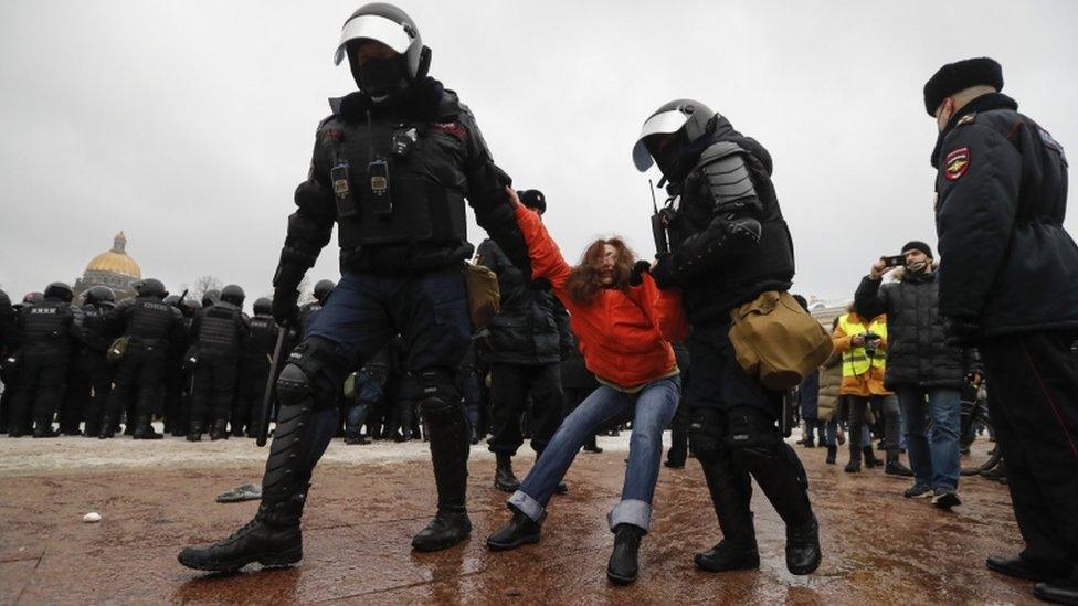 Russian special police units officers detain a female protester in St Petersburg