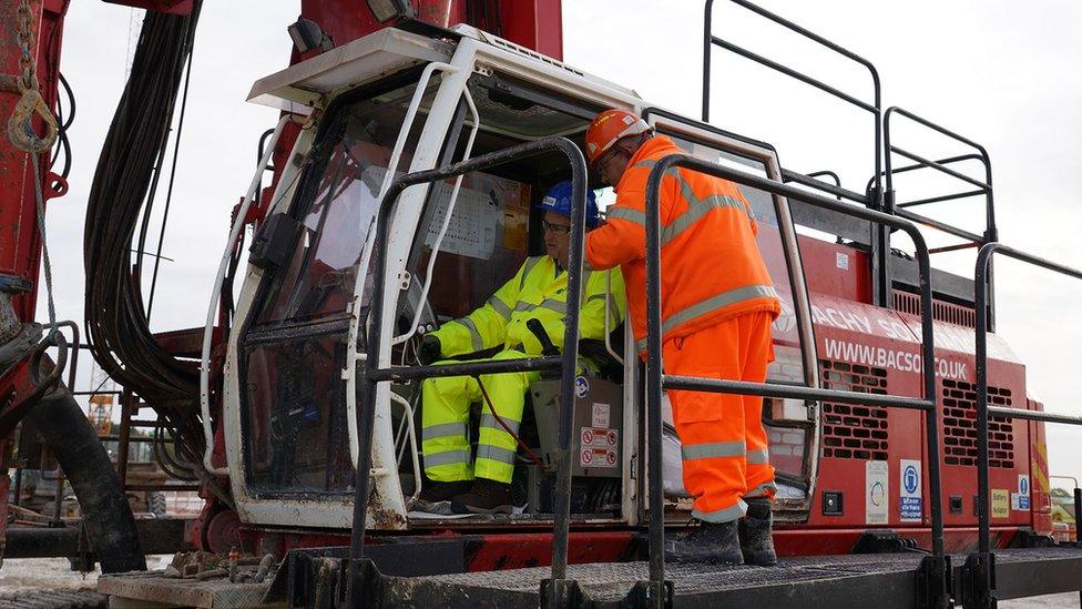 Two construction workers in a crane vehicle