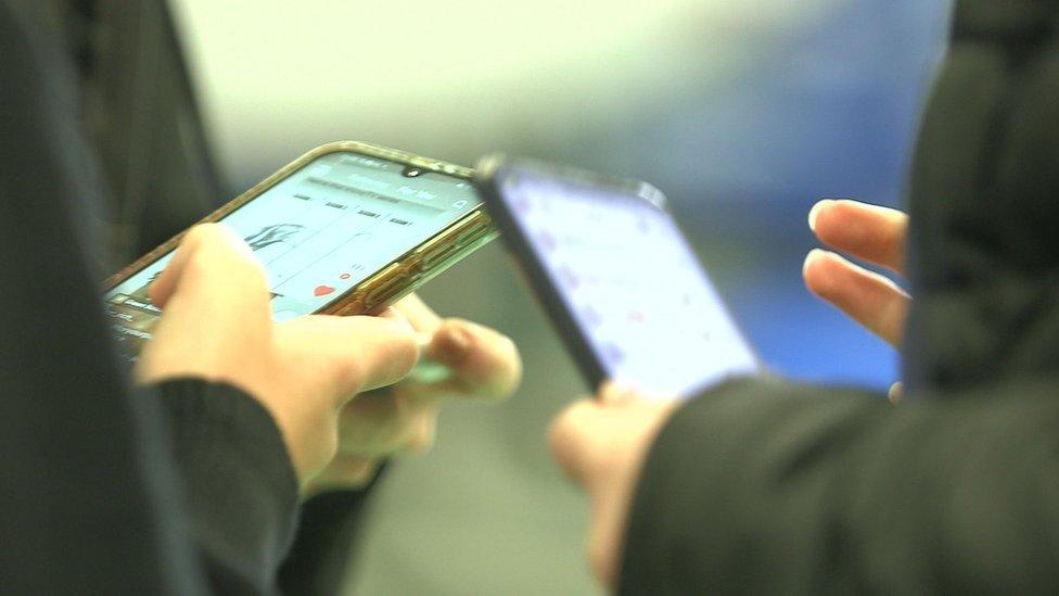 Two teens hands holding smartphones