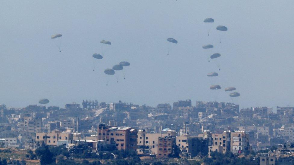 Aid is dropped by a plane over Gaza, as seen from Israel (13 March 2023)