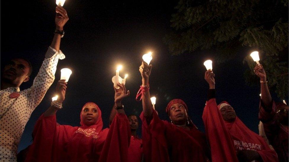 Bring Back Our Girls (BBOG) campaigners raise up candles during a candle light gathering marking the 500th day since the abduction of girls in Chibok, along a road in Abuja, 27 August 2015