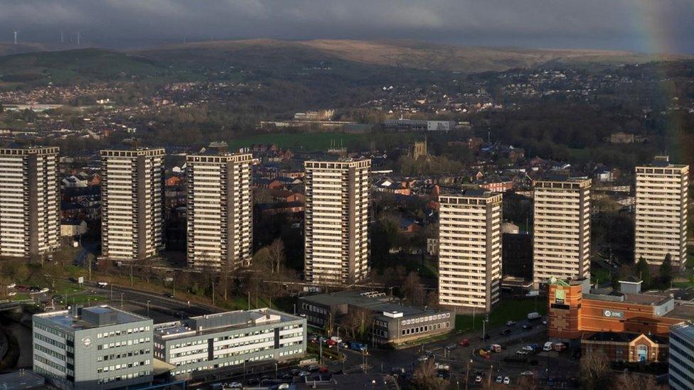 A drone view of a rainbow behind the seven sisters residential tower blocks