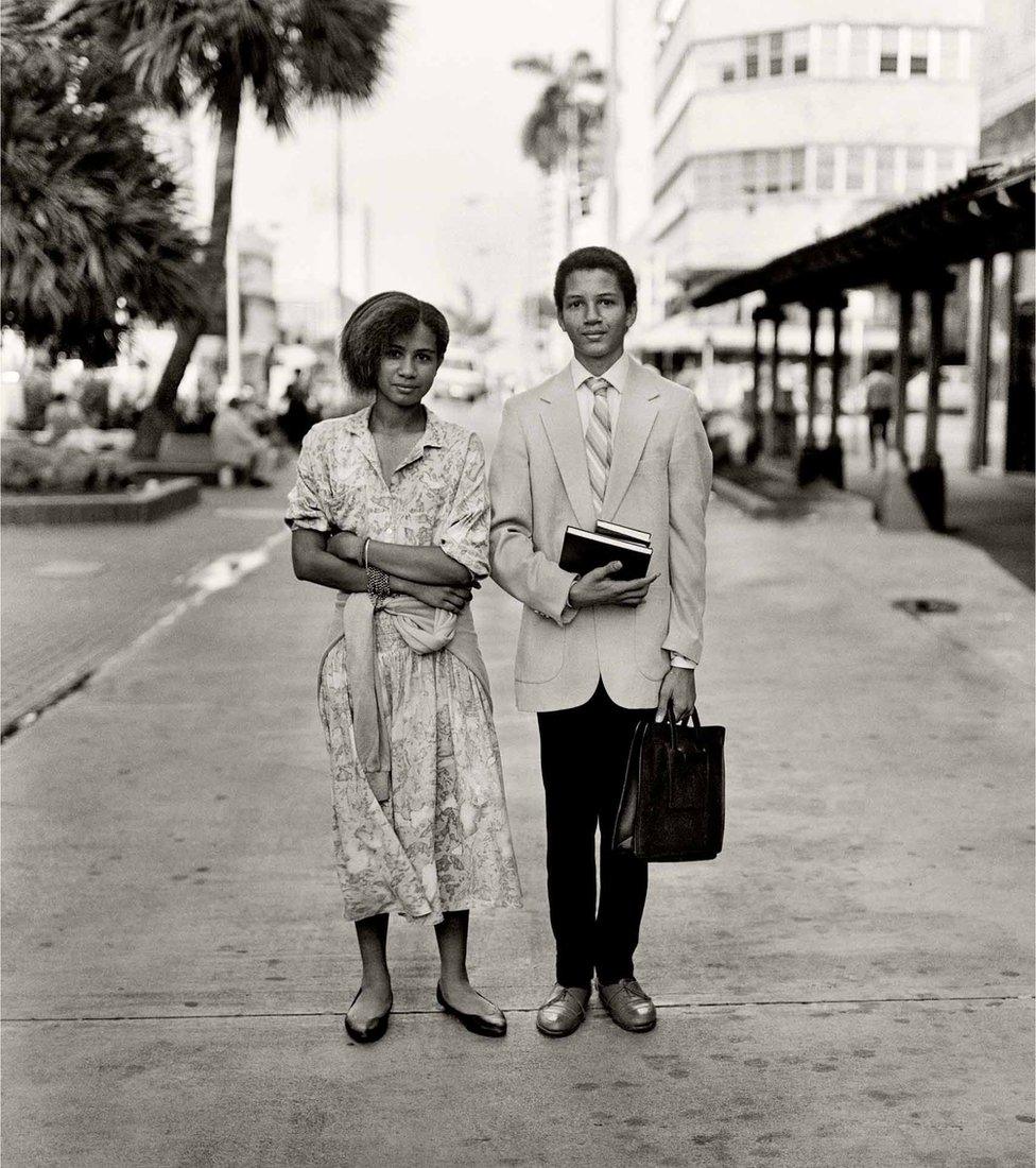 A well-dressed couple pose of the camera