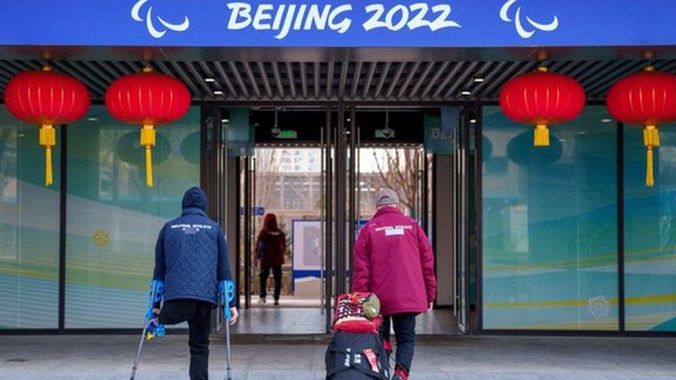 Neutral athletes of the team formerly known as the Russian Paralympic Committee arrive at the Paralympic Village with tape covering the word Russia on their clothing ahead of the Beijing 2022 Winter Paralympic Games