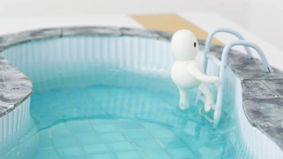 A swimming pool at the top of the apartment model which features an animation figure called Okki