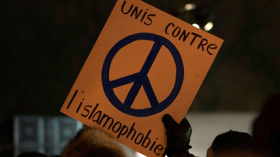 A person holds a sign "United against Islamophobia" during a rally near the Islamic Cultural Centre