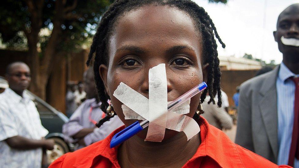 A protestor at the Daily Monitor newspaper poses in Kampala on May 20, 2013