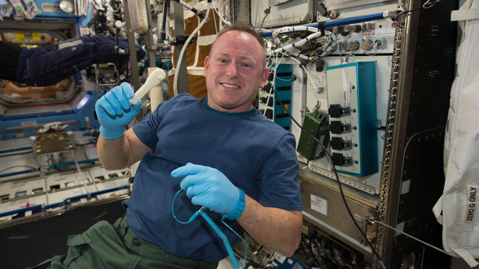 Astronaut Barry Wilmore shows off a ratchet wrench made with a 3D printer on the ISS