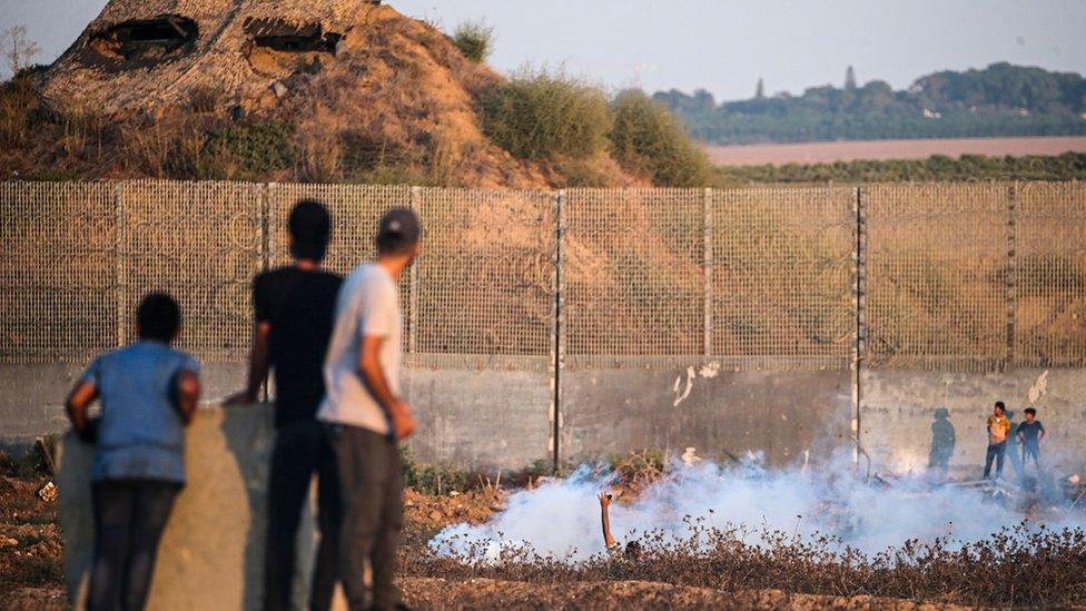 A Palestinian protester (C) asks for help after he was injured during during a violent demonstration by the Gaza-Israel separation fence (19 September 2023)