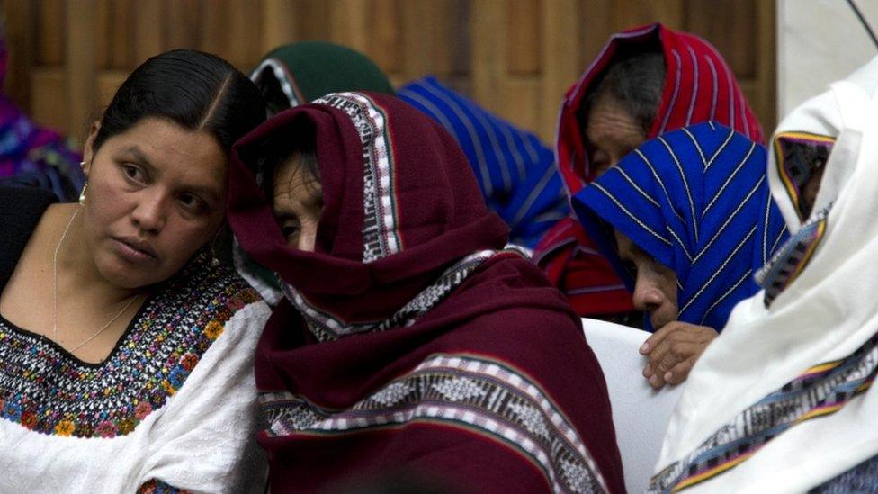 Victims of sexual violence cover their faces as they listen to an interpreter, left, on the first day of hearings for a trial against a former military officer and former paramilitary fighter accused of sexual violence during Guatemala's civil war in Guatemala City, Monday, Feb. 1, 2016.