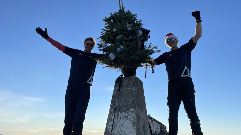 Ed Jackson and Ross Stirling at the top of Ben Nevis holding a decorated Christmas tree